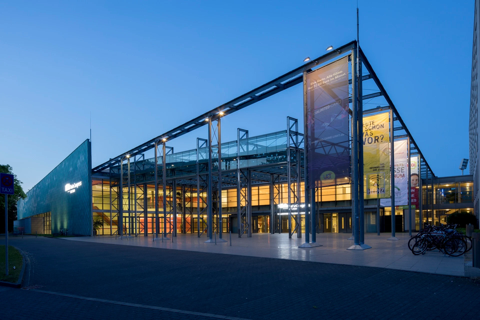 RuhrCongress Bochum exterior at dusk, with its glass canopy and illuminated entrance