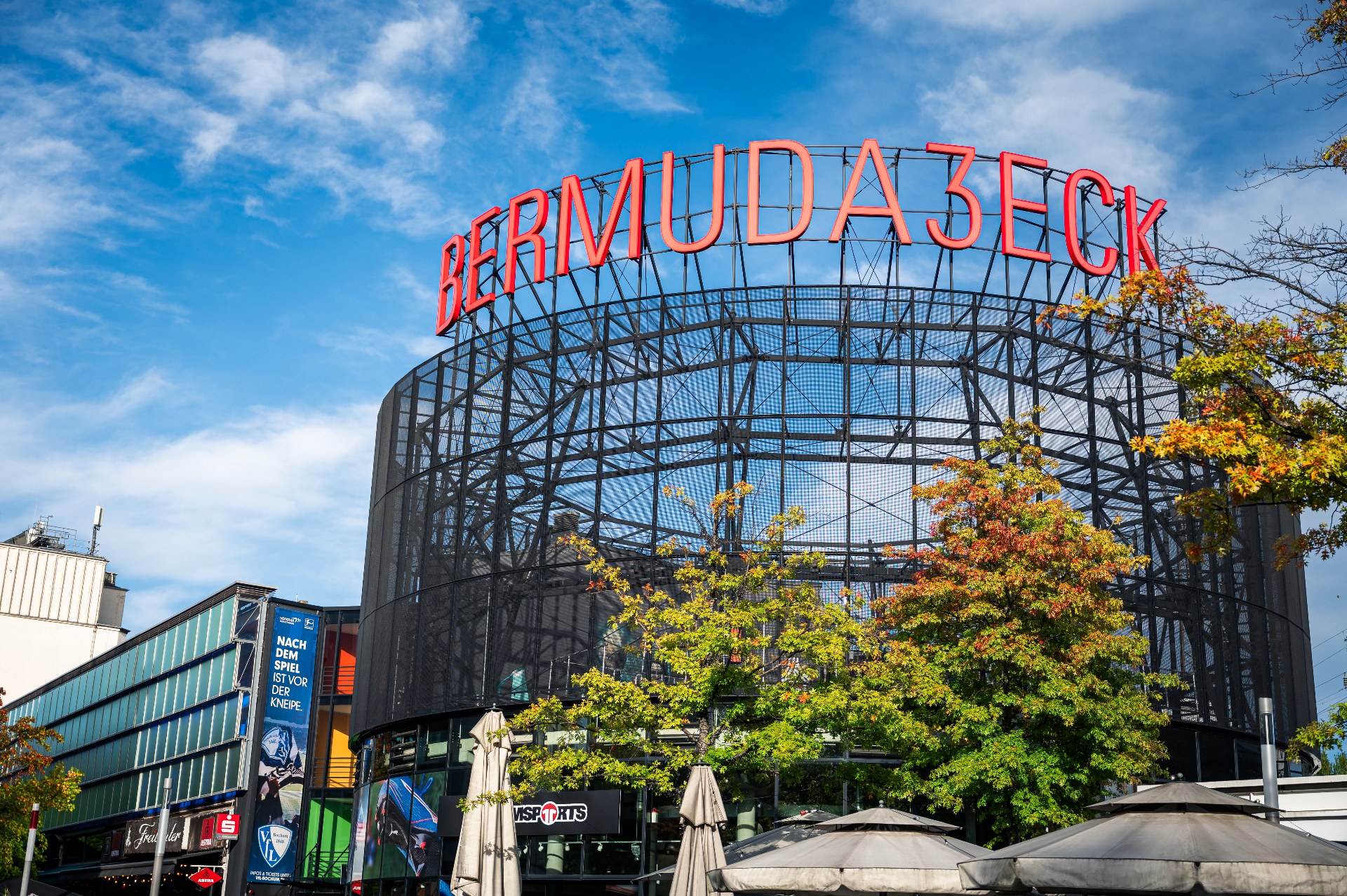 The red Bermuda3Eck sign above outdoor terraces in Bochum